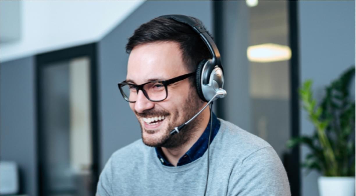 Joven con audífonos escuchando audio desde el computador 